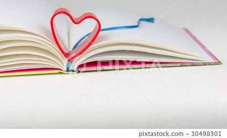 Red heart over diary book with bookmark on white Red heart over diary book with bookmark on white 30498301