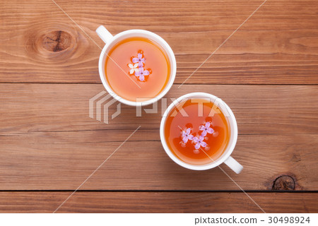 Two cups of tea with lilac flowers . Two cups of tea with lilac flowers . 30498924
