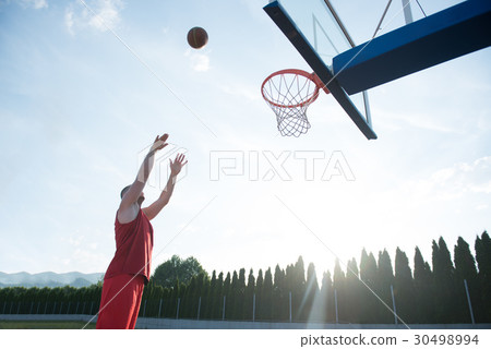 Young man jumping and making a fantastic slam dunk Young man jumping and making a fantastic slam dunk 30498994