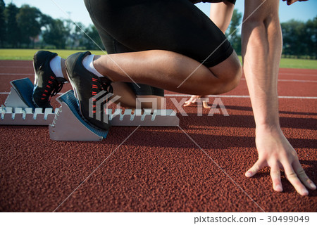 Runners preparing for race at starting blocks Runners preparing for race at starting blocks 30499049