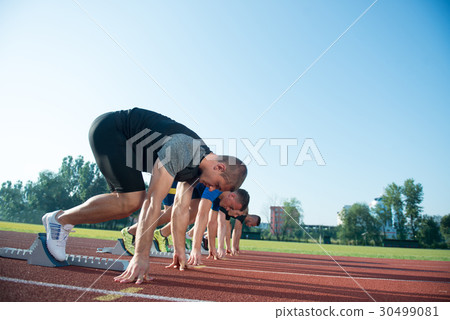 Runners preparing for race at starting blocks 30499081