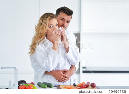 Happy couple cooking breakfast together in the Happy couple cooking breakfast together in the 30499586