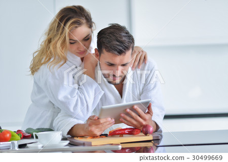 Happy couple cooking breakfast together in the 30499669
