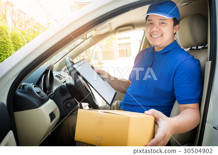 Delivery man with cardboard box checking document list In van an Delivery man with cardboard box checking document list In van an 30504902