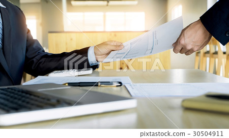 Businessman his colleague giving contract to read and sign 30504911
