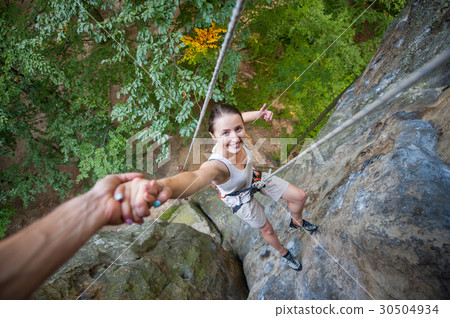 Female climber on high rock wall 30504934