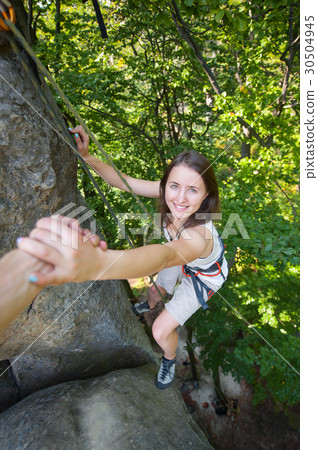 Female climber on high rock wall 30504945