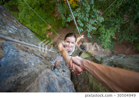 Female climber on high rock wall 30504949
