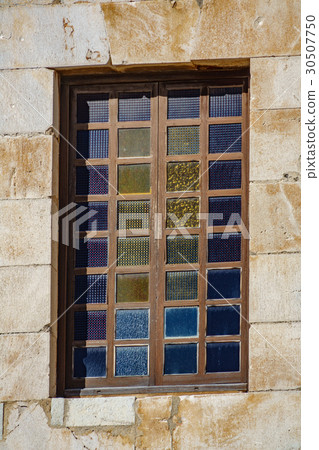 Closeup of colored window and stone wall Closeup of colored window and stone wall 30507750