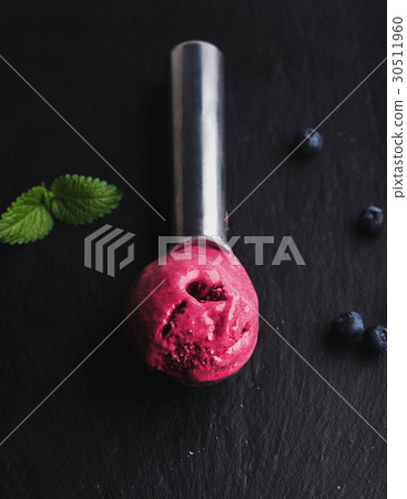 Blueberry ice-cream scoop over black slate stone Blueberry ice-cream scoop over black slate stone 30511960