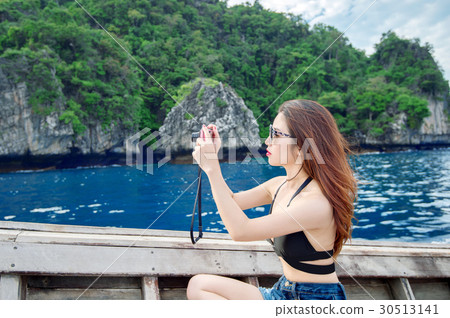 Young woman taking photo of beautiful sea. 30513141