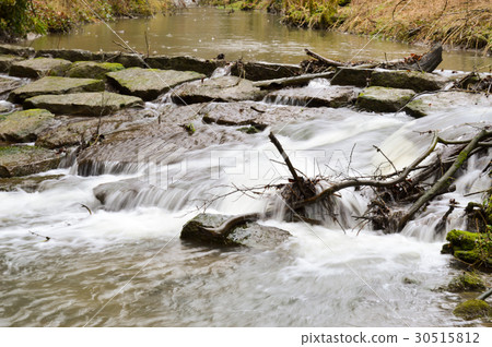 Small waterfall on a stone dam Small waterfall on a stone dam 30515812