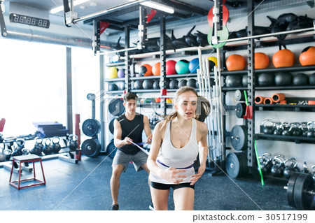 Strong woman using a resistance band in her 30517199