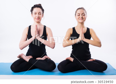 Two women doing yoga and meditating in lotus Two women doing yoga and meditating in lotus 30519450