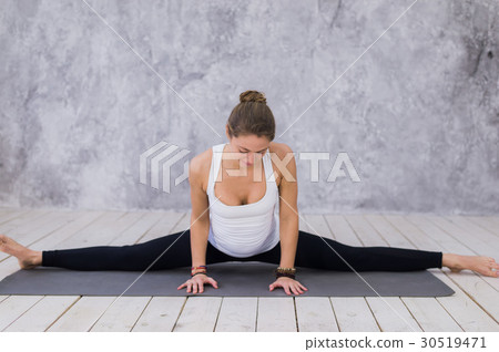 A sportive young girl stretching legs, yoga class A sportive young girl stretching legs, yoga class 30519471