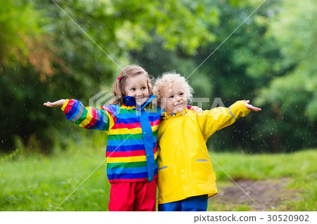 Kids play in rain and puddle in autumn 30520902