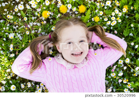 Child on green grass lawn with summer flowers Child on green grass lawn with summer flowers 30520996