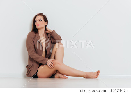 Beautiful girl in a jacket sits on the floor 30521071