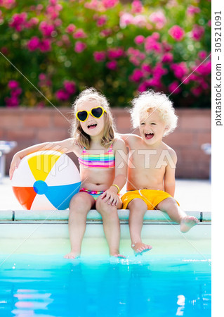 Kids playing at outdoor swimming pool 30521091