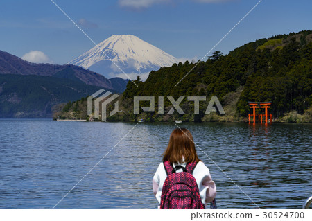 A torii of Hakone shrine in Lake Ashi and a foreign tourist watching Mt. Fuji 30524700