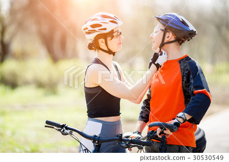 Two friends wear bike helmets Two friends wear bike helmets 30530549