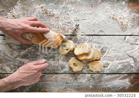 Bakery concept background. Hands cutting bread Bakery concept background. Hands cutting bread 30532228