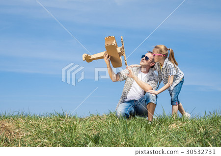 Father and daughter playing with toy airplane Father and daughter playing with toy airplane 30532731