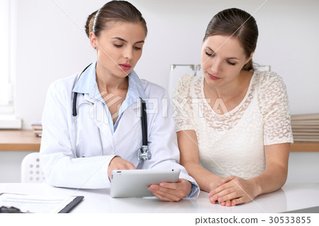 Doctor and  patient  sitting at the desk. Medici 30533855