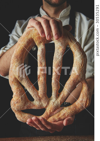 Baker holding fougas bread Baker holding fougas bread 30535291