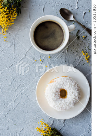 Cup of coffe and a donut on concrete background Cup of coffe and a donut on concrete background 30535910