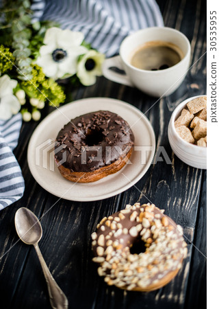 Cup of coffe and a chocolate donuts on black wood 30535955