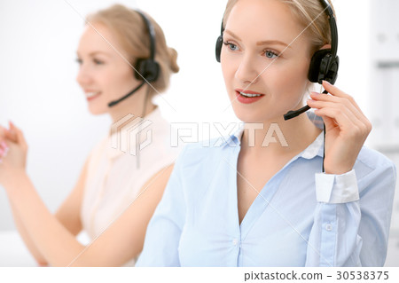 Call center. Focus on beautiful blonde woman in 30538375