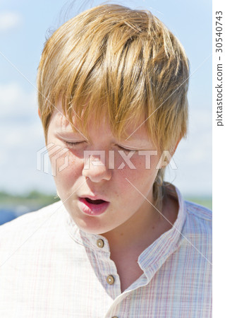 Portrait of squint blond boy near river 30540743