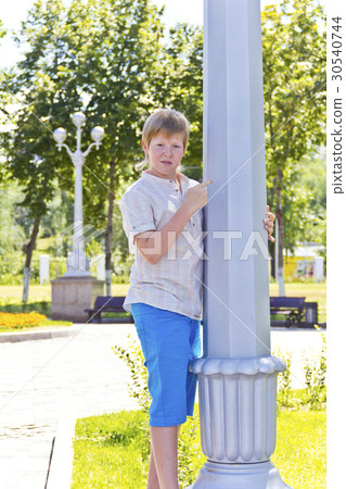 Boy looks at a white column 30540744