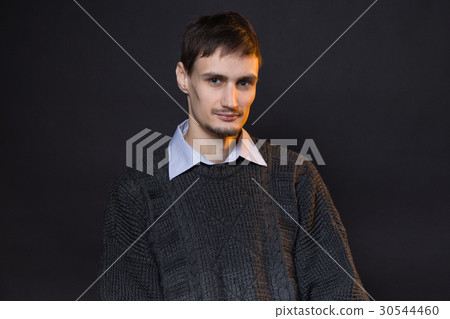 Serious brunette man wearing gray sweater 30544460