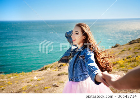 Follow me there. Beautiful young woman holds the Follow me there. Beautiful young woman holds the 30545714