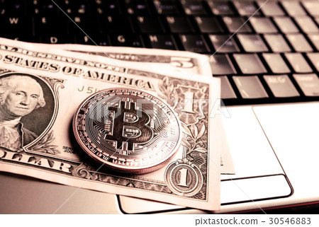 bitcoin on dollar bill over laptop bitcoin on dollar bill over laptop 30546883