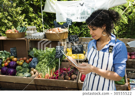 Greengrocer selling organic fresh agricultural product at farmer market 30555522