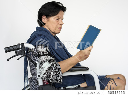 Woman is sitting on a wheelchair Woman is sitting on a wheelchair 30558233