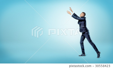 A businessman in side view with both hands raised A businessman in side view with both hands raised 30558423
