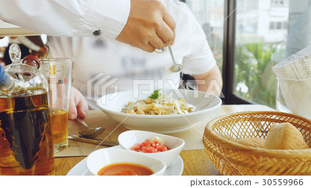 Hand of a chef puts the Parmesan over the pasta 30559966