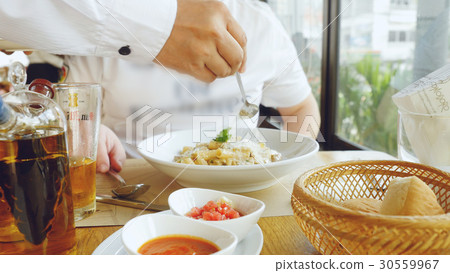 Hand of a chef puts the Parmesan over the pasta 30559967