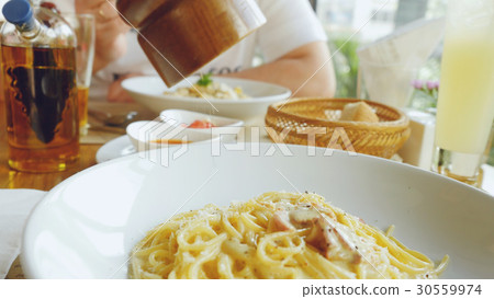 Hand of a chef puts the Parmesan over the pasta 30559974