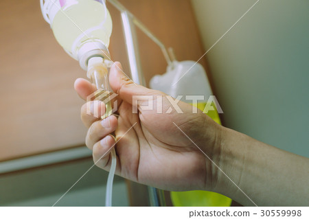 Close up hand adjust saline IV drip for patient  30559998