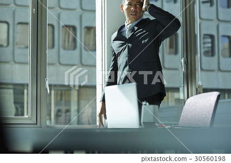 The businessman with a hand on head is worried something. 30560198