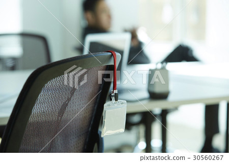 the employee ID card is hung on the chair. 30560267