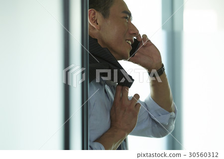 the businessman is happily talking on phone. 30560312