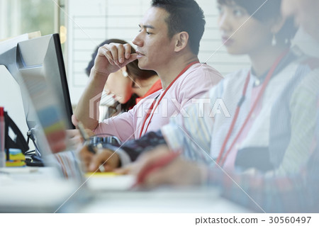 A portrait of a man looking and thinking next to colleagues A portrait of a man looking and thinking next to colleagues 30560497