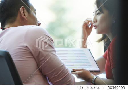 Two colleagues are discussing a new strategy in office. 30560603