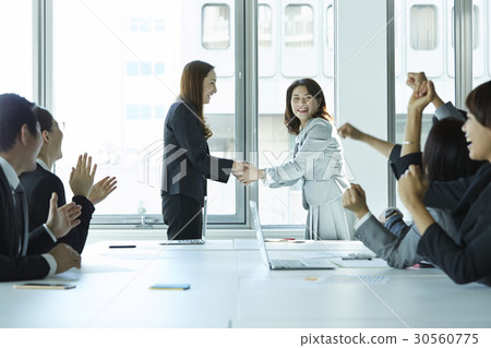 a congratulation on two women shaking hands and smiling 30560775